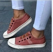 Round head stretch canvas shoe worn by a model with a stylish outfit featuring light denim jeans.