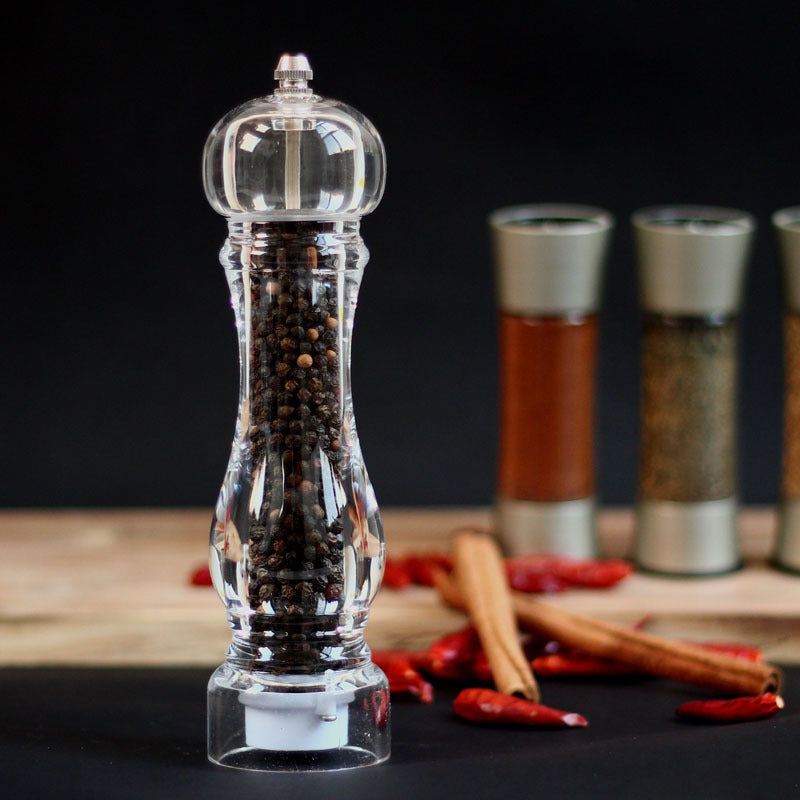 Creative kitchen appliances hand glass grinder with pepper mill beside spices and herbs.