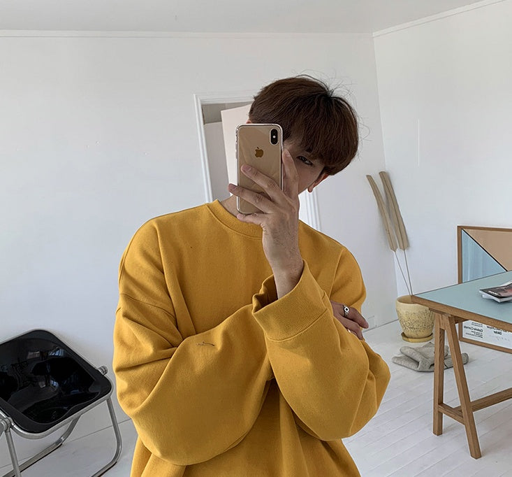 Round Neck Sweater Men's And Women's in a bright yellow color, worn by a person taking a selfie in a stylish room.