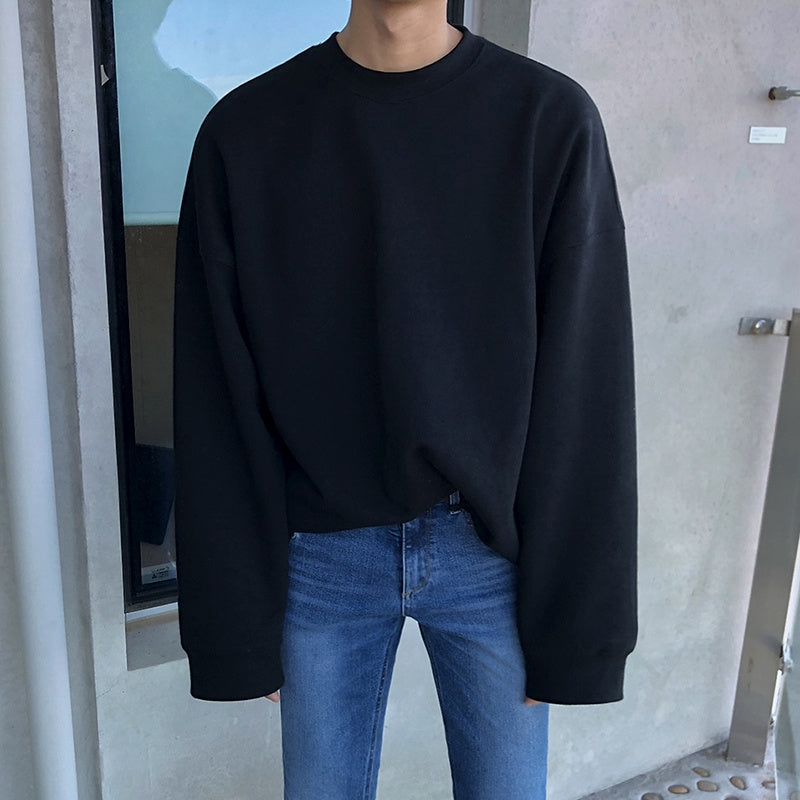 Round Neck Sweater Men's And Women's displayed in black color on a model wearing jeans.