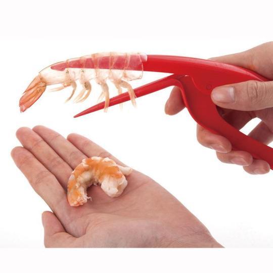 A person using a Shrimp Peeler Kitchen Appliances to remove shell from shrimp in hand.