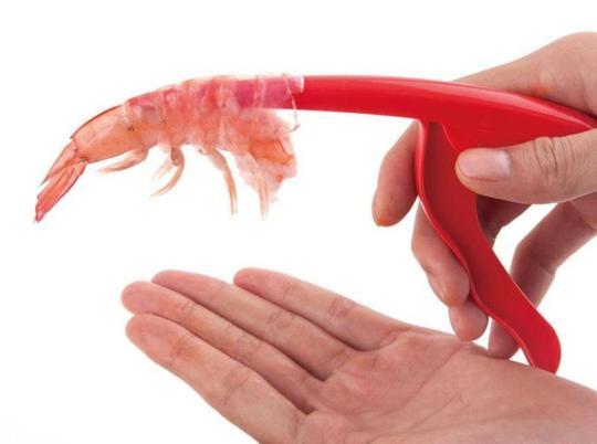 Person using a Shrimp Peeler Kitchen Appliances to easily peel shrimp, showcasing the device in action.