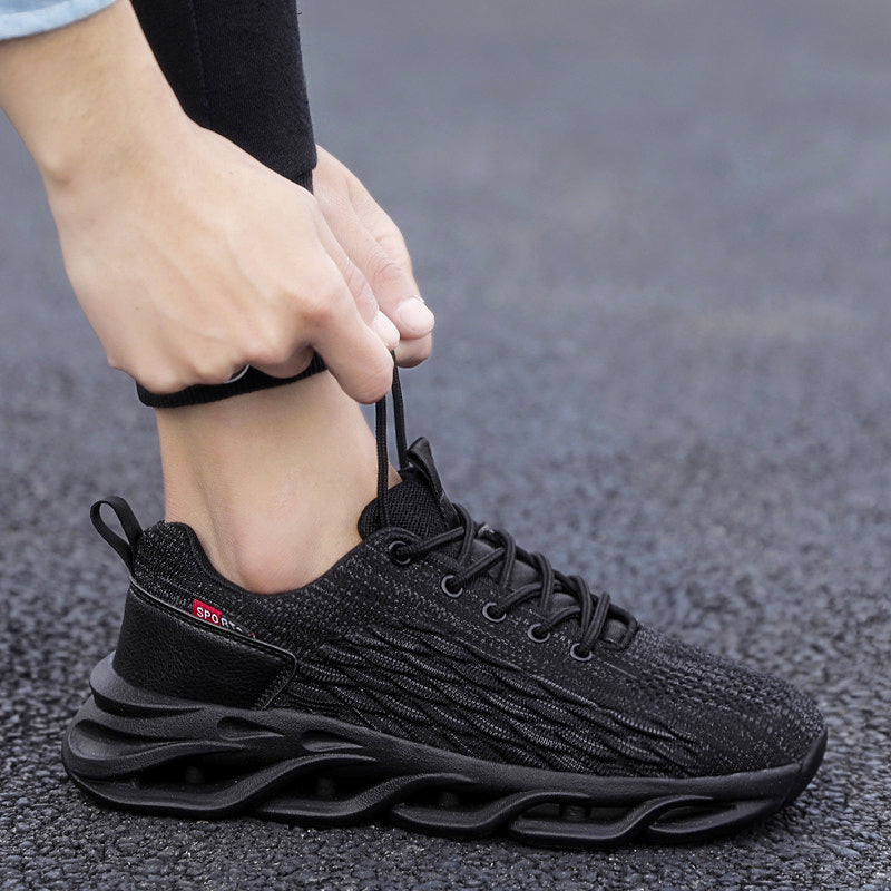 Person tying laces on Fly weave running breathable mesh shoes in black, showcasing style and comfort.