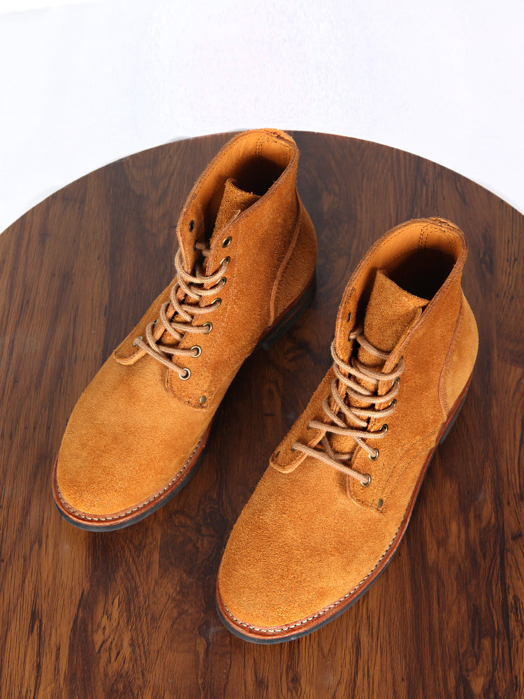 Vintage Work Boots High Top shoe displayed on a wooden table, showcasing their rugged design and vintage style.