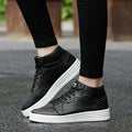 Round Head High-Top Strap Flat White Shoes Men worn with black pants on a wet surface.