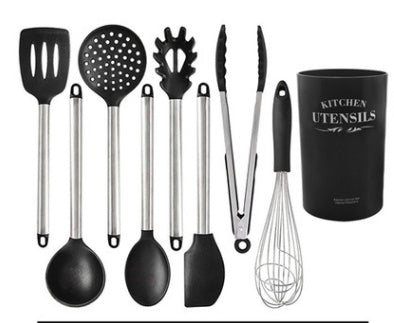 The silicone kitchen utensils and appliances including spatula, spoons, tongs, and whisk in a kitchen utensil holder.
