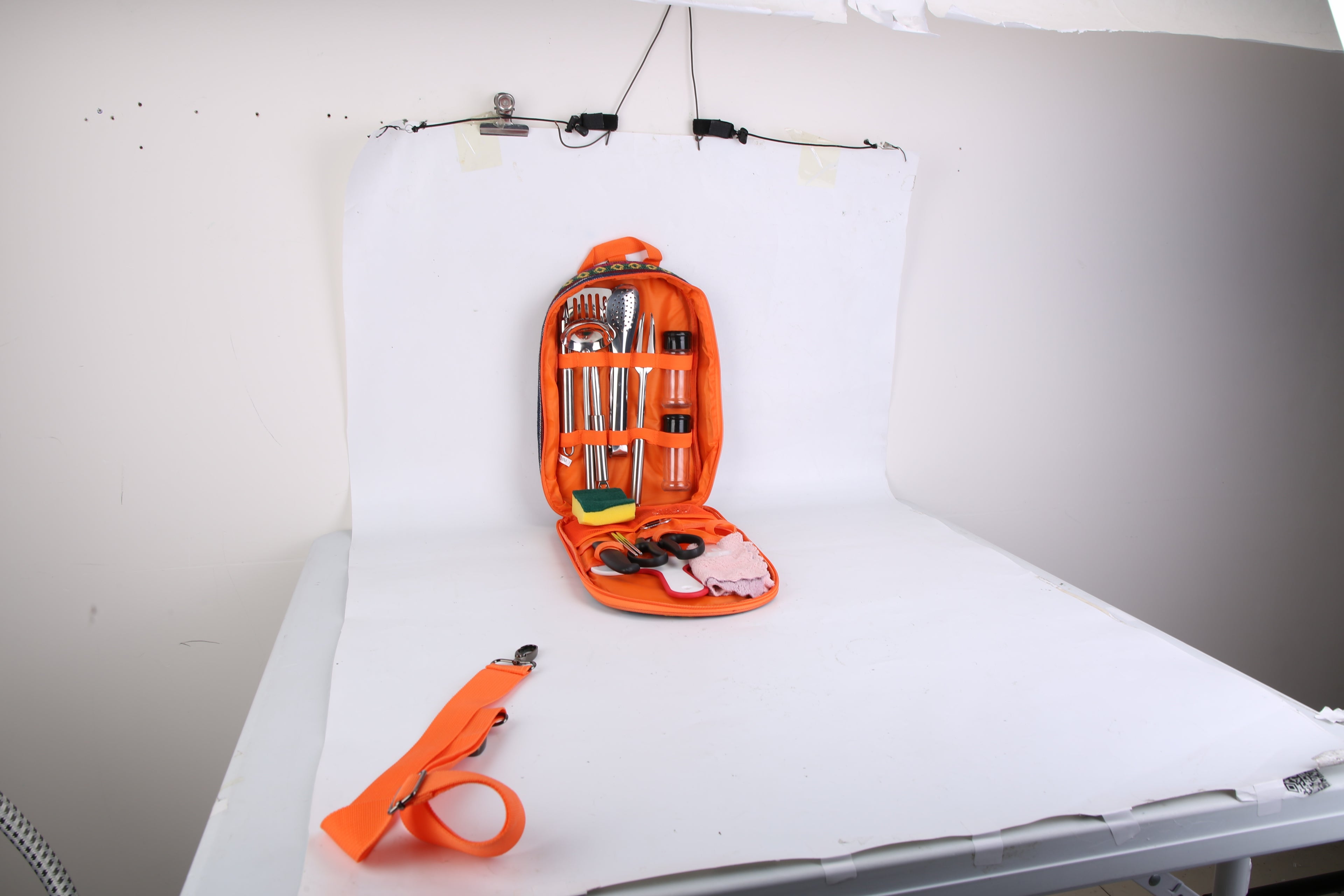 Camping Cooking Utensil Kit Portable Picnic Cookware displayed open with utensils and tools in an orange carrying case.