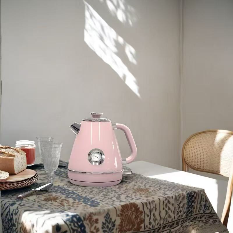 Household Small Appliances Electric Kettle in pink color on a table with bread and drinks.