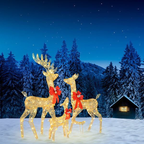 Golden Elk Family Courtyard Elk Decoration illuminated in snowy landscape with red bows and festive lights.