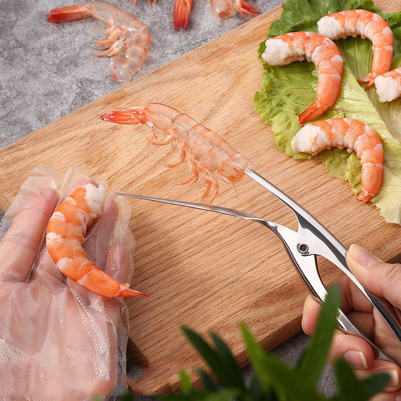 Person using Shrimp Peeler Kitchen Appliances to easily peel shrimp on a wooden cutting board.