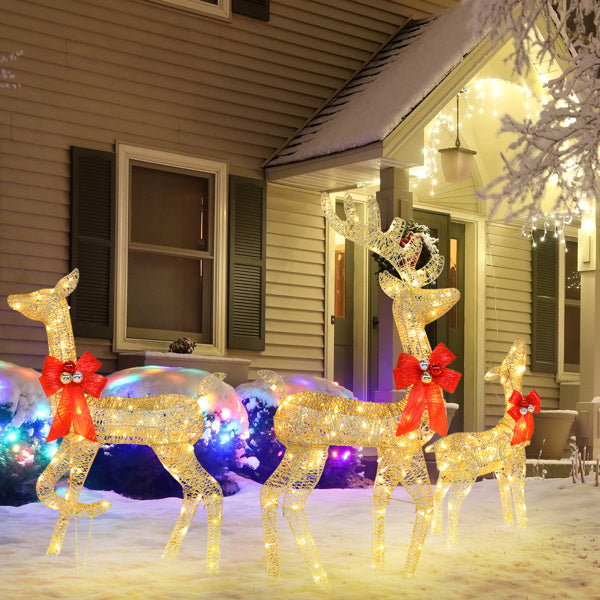 Golden Elk Family Courtyard Elk Decoration illuminated in winter yard with festive bows and lights.