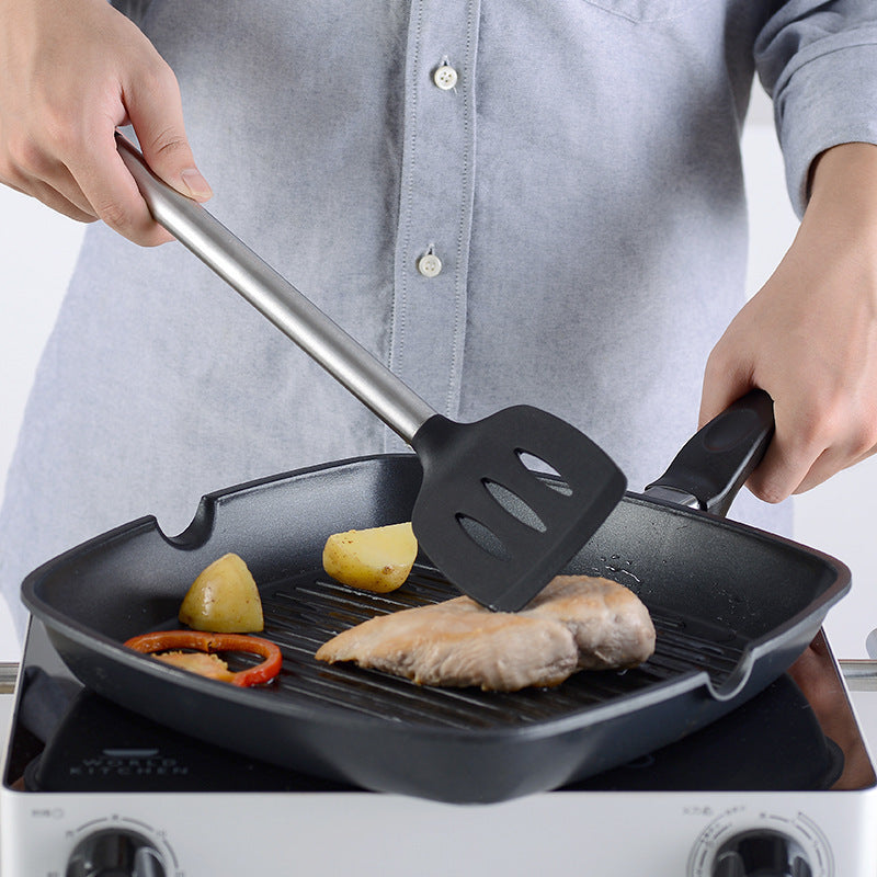 Kitchen Gadgets Cooking Silicone Spatula Spoon Set in use, flipping fish on a grill pan with vegetables.