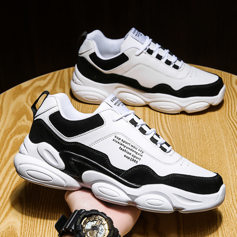 Men's Casual Sneakers Youth Trend Thick Sole in black and white design on wooden surface.