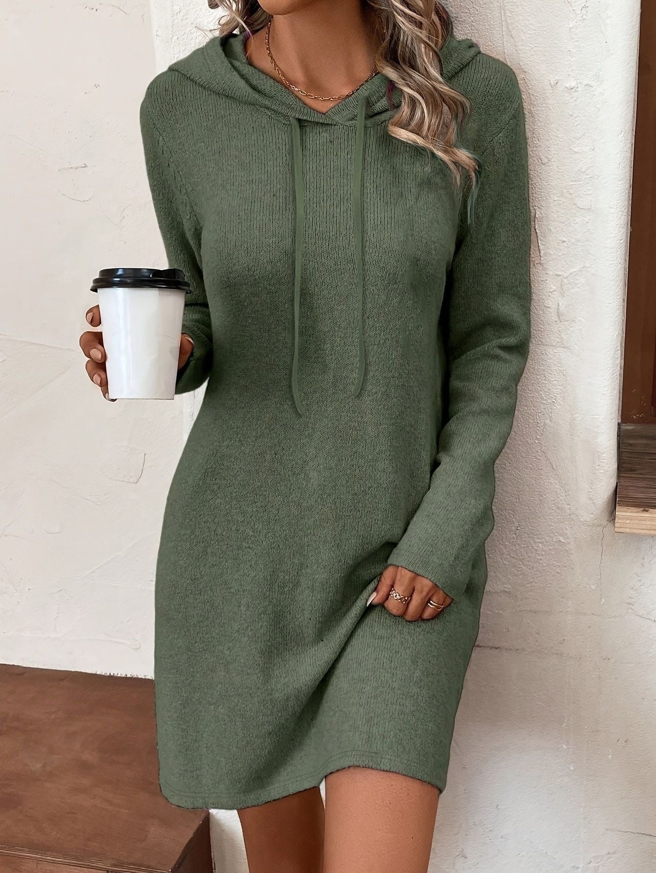 Woman wearing a green Long Sleeve Dress For Women with a hood, holding a coffee cup, showcasing casual style.